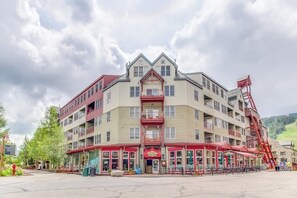 A multi-story hotel with a central atrium, balconies, and a red exterior. - Bright and colorful studio with breathtaking mountain views (Keystone)