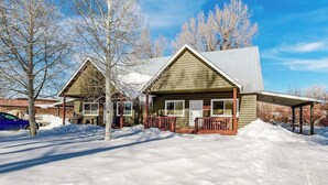 A two-story log cabin with a covered porch and a garage.