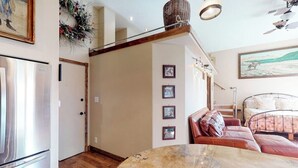 A kitchen with a marble countertop, a refrigerator, and a dining area with a table. - Stylish, downtown condo w/ loft, kitchen, & fireplace plus shared patio & grill (Durango)