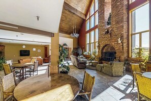 Eine großzügige Lobby mit hoher Decke, Kamin und bequemen Sitzbereichen.