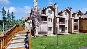 Un immeuble à plusieurs étages doté d’une terrasse en bois et d’un panneau indiquant « INTERDICTION DE STATIONNER ».