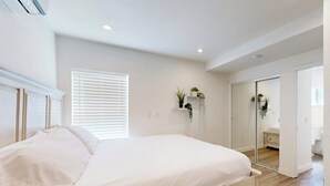 A bedroom with a bed, a mirror, a closet, and a window with blinds. - Cozy, Single-Level Getaway with Fast WiFi, Kitchenette, & A/C - Dogs Welcome (Newport Beach)