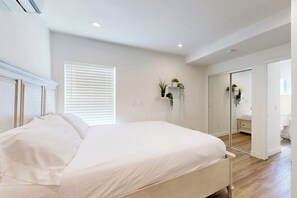 A bedroom with a bed, a mirror, a closet, and a window with blinds. - Cozy, Single-Level Getaway with Fast WiFi, Kitchenette, & A/C - Dogs Welcome (Newport Beach)