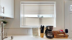 A kitchen with a window, a coffee maker, and a knife block. - Cozy, Single-Level Getaway with Fast WiFi, Kitchenette, & A/C - Dogs Welcome (Newport Beach)