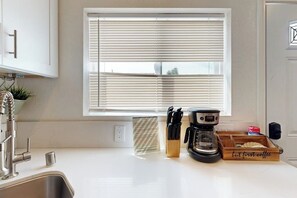 A kitchen with a window, a coffee maker, and a knife block. - Cozy, Single-Level Getaway with Fast WiFi, Kitchenette, & A/C - Dogs Welcome (Newport Beach)