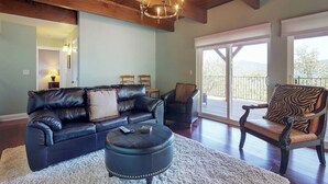 A living room with a leather sofa, ottoman, and a zebra-patterned chair. - Upscale home with lake views, gas grill, washer/dryer, fireplace, patio, deck (Lake Arrowhead)