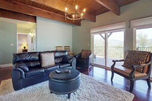 A living room with a leather sofa, ottoman, and a zebra-patterned chair. - Upscale home with lake views, gas grill, washer/dryer, fireplace, patio, deck (Lake Arrowhead)