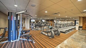 Ein Fitnessraum mit Trainingsgeräten, einer Gewichtshalterung und einem gemusterten Teppich.