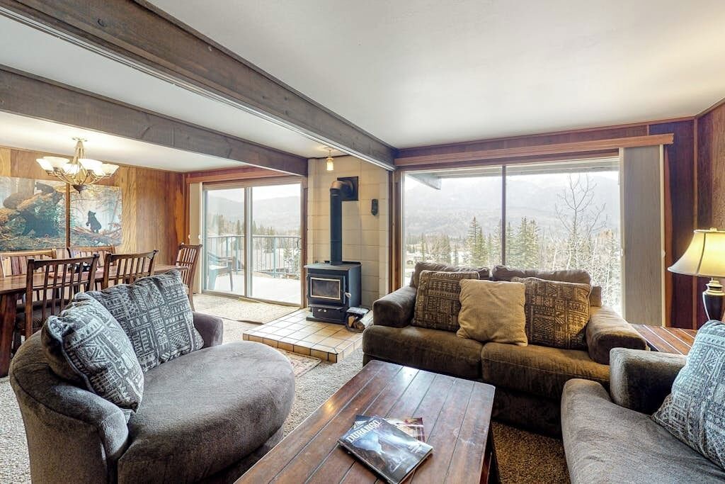 A cozy living room with a fireplace, comfortable seating, and a dining area with a view.