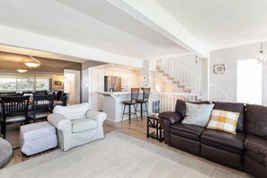 A spacious living area with a sofa, chairs, and a dining table. - Spacious Home w/ Fenced Patio, Grill & Balcony - 1 Mile to Beach & Pier Ave (Hermosa Beach)
