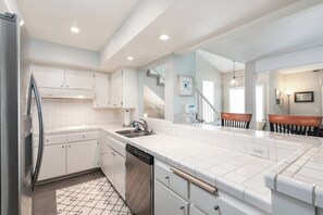 A modern kitchen with white cabinets, a stainless steel refrigerator, a dishwasher, and a tiled backsplash. - Spacious Home w/ Fenced Patio, Grill & Balcony - 1 Mile to Beach & Pier Ave (Hermosa Beach)
