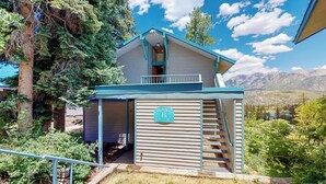 A building with a balcony, a staircase leading to the entrance, and a sign indicating 'Building B.' - Ski-in/ski-out condo with on-site spa, balcony, fireplace & lake views (Durango)