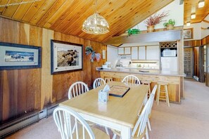 A wooden interior with a dining table, chairs, a kitchen area, and framed pictures on the wall. - Ski-in/ski-out condo with on-site spa, balcony, fireplace & lake views (Durango)