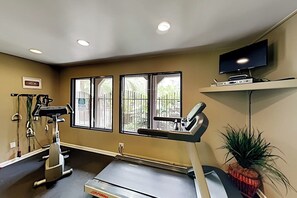 A gym with exercise equipment, windows, a television on a shelf, and a potted plant. - Pacific Cove | Pool & Hot Tub, Fitness Center | Walk to Beach & Dining (Playa Del Rey)