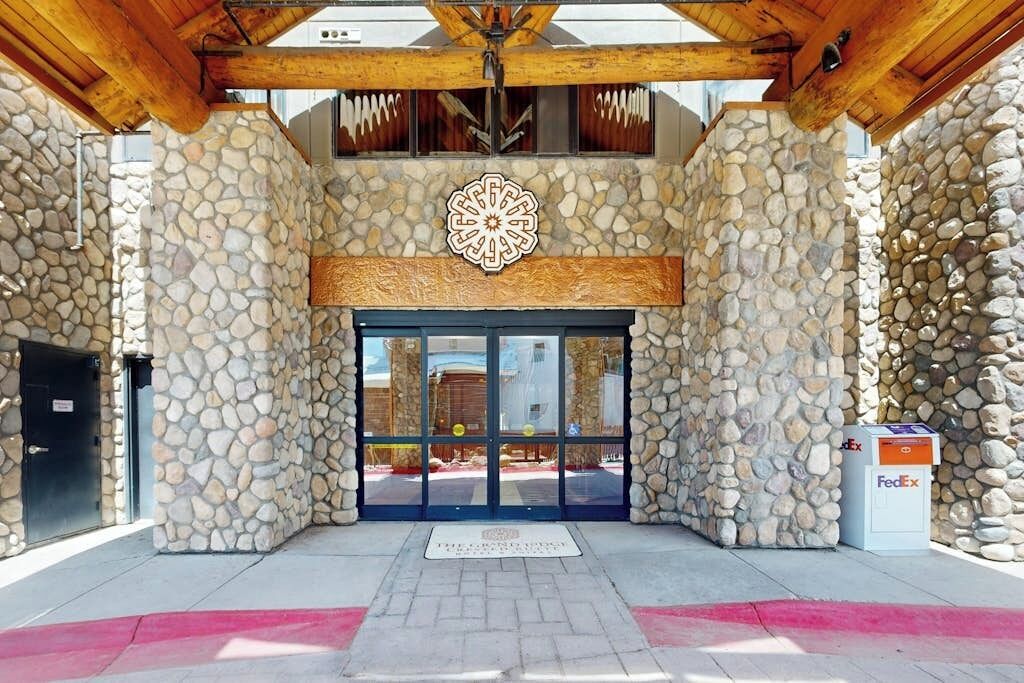 Une façade en pierre avec une grande fenêtre circulaire et une boîte aux lettres FedEx.
