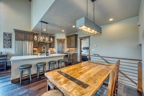 A spacious kitchen with a large island, bar stools, and pendant lighting. - New condo with fireplace - walk to dining & shopping, bus to slopes (Frisco)