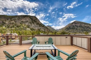A deck with a table and chairs, overlooking a mountainous landscape. - New condo with fireplace - walk to dining & shopping, bus to slopes (Frisco)