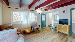A room with a bed, a round table, a television, and a cabinet.