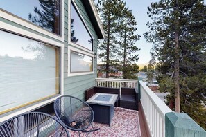 Ein Balkon mit Stuhl, Tisch und Geländer.