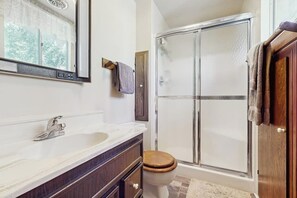A bathroom with a shower, a sink, a toilet, and a mirror. - Rustic, wooded escape near the village w/ a lovely deck (Lake Arrowhead)