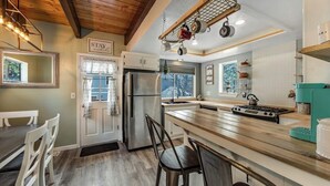 A kitchen with a wooden island, stainless steel appliances, and hanging pots. - Dog-friendly retreat with fast WiFi, washer/dryer & wood-burning fireplace (Running Springs)