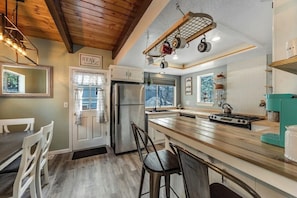 A kitchen with a wooden island, stainless steel appliances, and hanging pots. - Dog-friendly retreat with fast WiFi, washer/dryer & wood-burning fireplace (Running Springs)