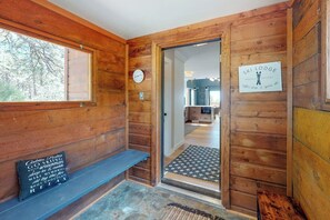 Ein Holzblockhaus-Interieur mit einer Bank, einer Uhr und einem Schild, das es als Skihütte kennzeichnet.
