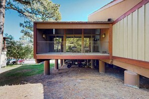 Ein Gebäude mit einer Holzterrasse und einem überdachten Bereich mit Fenstern.