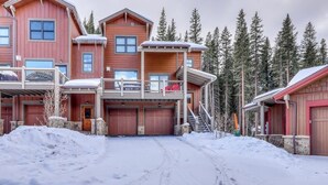 Un bâtiment en bois à plusieurs étages, doté d’une allée couverte et dont le sol est recouvert de neige.