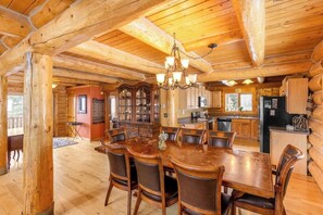 A log cabin interior with a dining area, kitchen, and a large wooden dining table with chairs. - Rare mountain-view log home with hot tub, fireplace & WiFi - near Breckenridge (Alma)