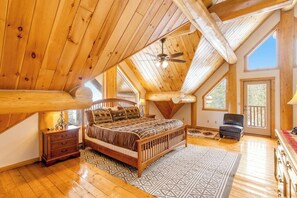 A bedroom with a wooden ceiling, a bed, a chair, and a window. - Rare mountain-view log home with hot tub, fireplace & WiFi - near Breckenridge (Alma)