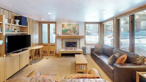 A cozy living room with a fireplace, a television, and a sofa. - Cozy condo w/ shared pool, hot tub & full kitchen - walk to lifts (Snowmass Village)