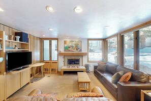 Ein gemütliches Wohnzimmer mit Kamin, Fernseher und Sofa.