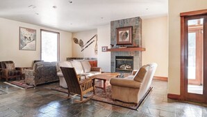 Ein großzügiges Wohnzimmer mit Kamin, einer Sofagarnitur und einem Couchtisch.