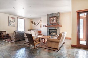 Ein großzügiges Wohnzimmer mit Kamin, einer Sofagarnitur und einem Couchtisch.