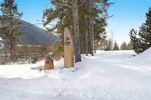 Eine verschneite Landschaft mit einem Holzschild für ORO Grande Lodge.