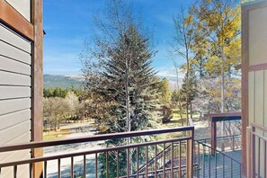 A balcony with a view of a tree and distant hills. - Studio condo w/ wifi, kitchenette, shared pool & hot tub - near golf & skiing (Durango)