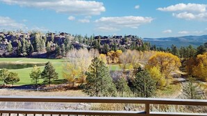 Ein malerischer Ausblick auf eine gebirgige Landschaft mit Golfplatz und Herbstlaub.