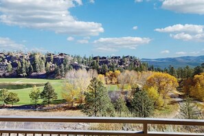 Ein malerischer Ausblick auf eine gebirgige Landschaft mit Golfplatz und Herbstlaub.