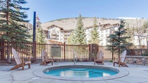 A pool area with Adirondack chairs, a wooden fence, and a sign labeled 'SPA RULES.' - Family-friendly mountain condo w/balcony, shared hot tub, & mountain views (Copper Mountain)
