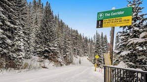A snowy landscape with a sign indicating 'The Corridor' and a warning for Iron Horse Guests not to block the ski trail. - Ski-In/Ski-Out Studio with Gas Fireplace & Shared Pool, Hot Tub, Gym,  Game Room (Winter Park)