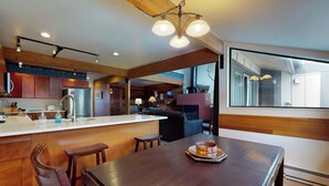 Una cucina moderna con mobili in legno, un'isola centrale e un'area pranzo con tavolo e sedie.