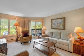 A living room with a sofa, armchair, coffee table, and lamps. - Mountain view condo w/gas fireplace, shared outdoor pool, and free WiFi (Copper Mountain)