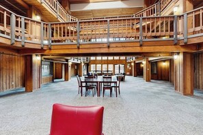 Ein mehrgeschossiges Interieur aus Holz mit einer zentralen Essecke, hohen Decken und freiliegenden Balken.