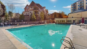 Ein Schwimmbecken mit klarem, blauem Wasser, umgeben von Gebäuden und Bäumen.