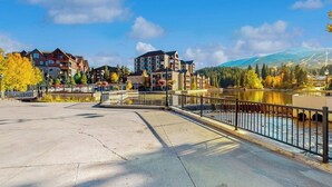 Une vue sur la rivière, avec des bâtiments, un pont et une montagne en arrière-plan.