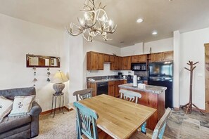 Une cuisine moderne avec des meubles en bois, un îlot central et un lustre.