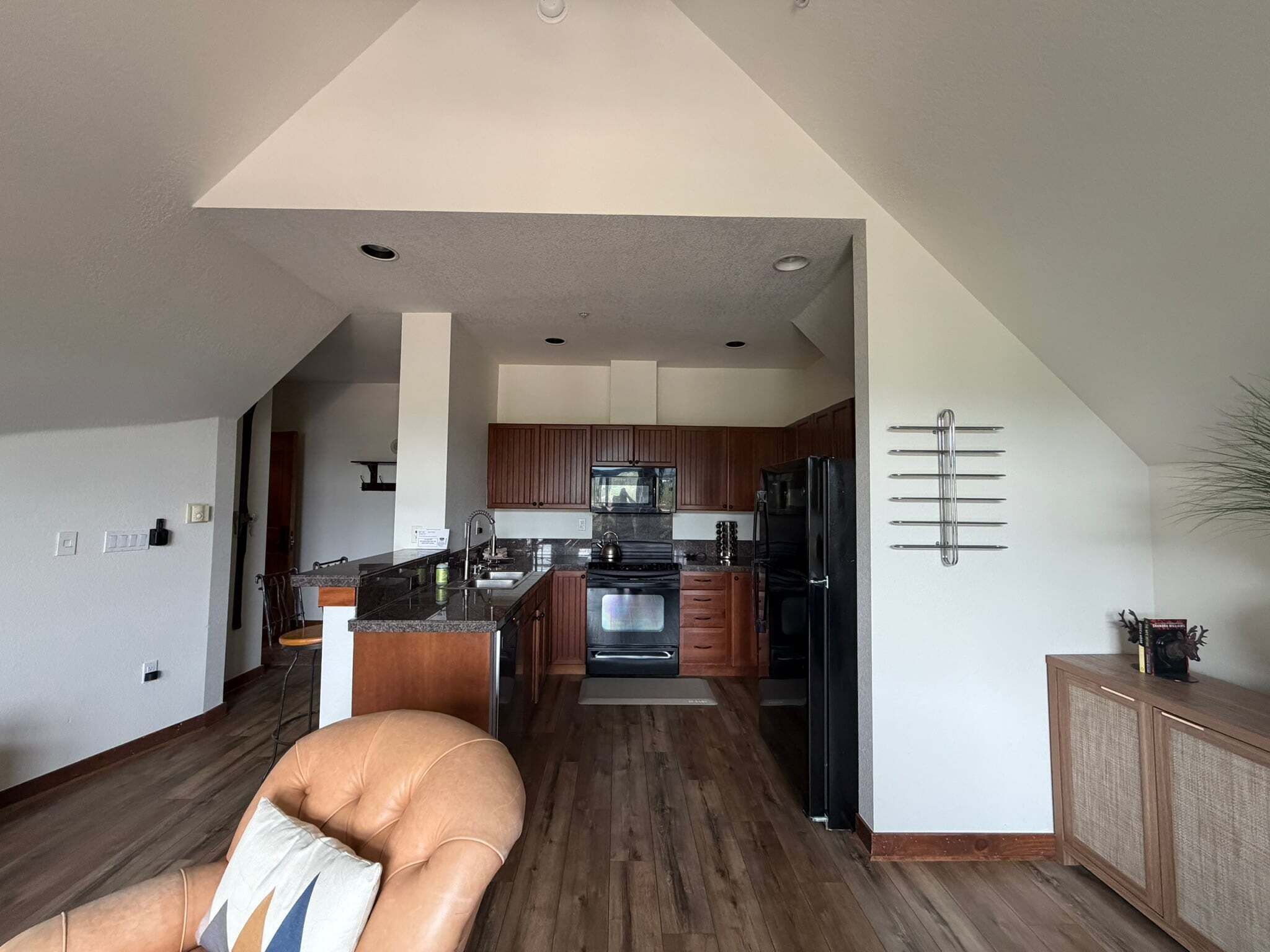 A modern kitchen with a central island, wooden cabinets, and a built-in oven.