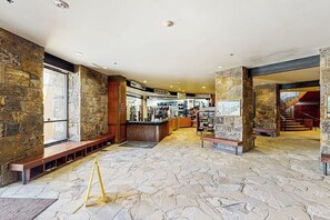 Eine Empfangshalle mit Steinwänden, einem Empfangstisch und einer Treppe.