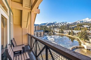 Ein Balkon mit Blick auf einen Fluss, Berge und Gebäude.